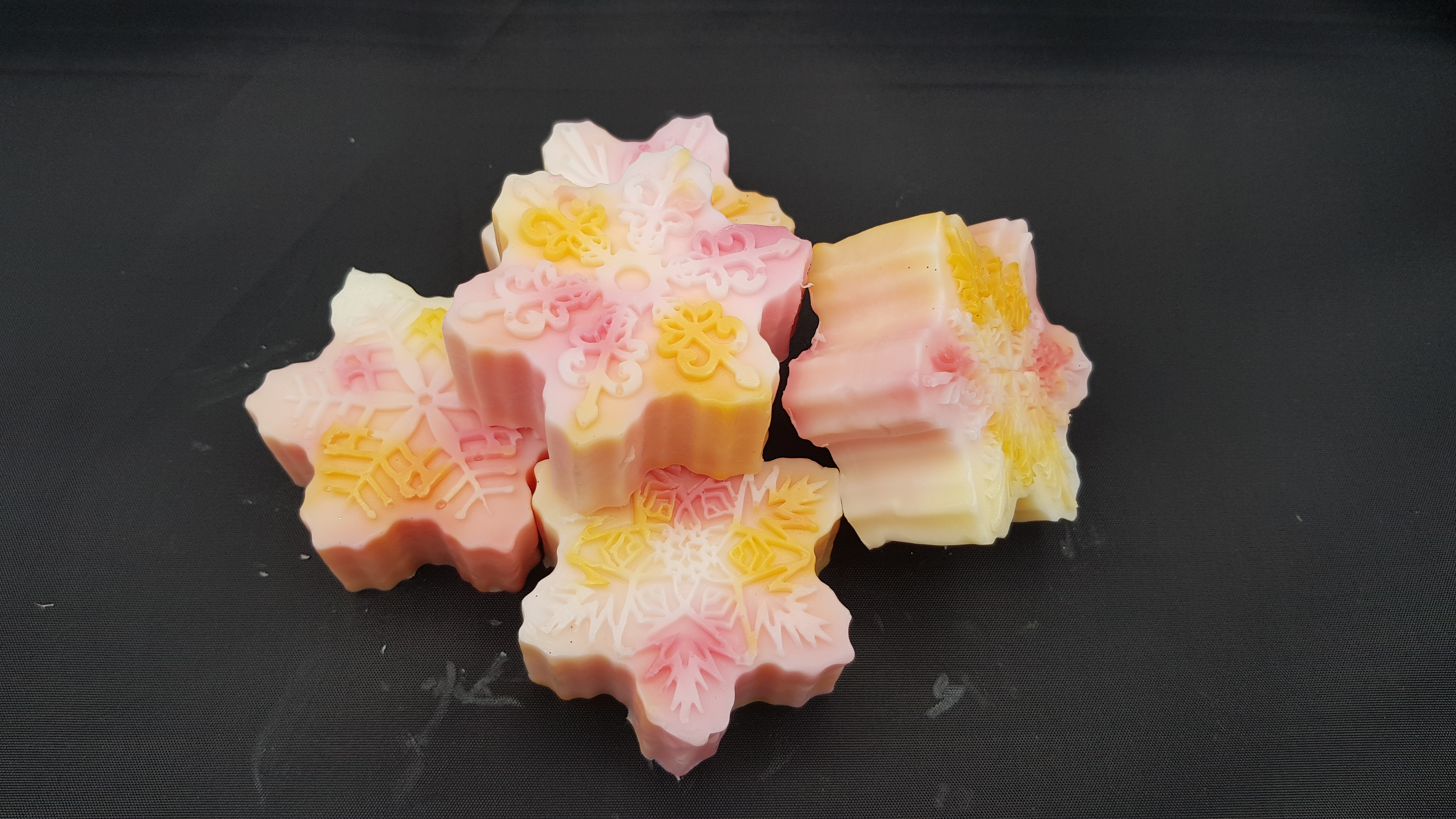 Pile of pink snowflake soaps on a table.
