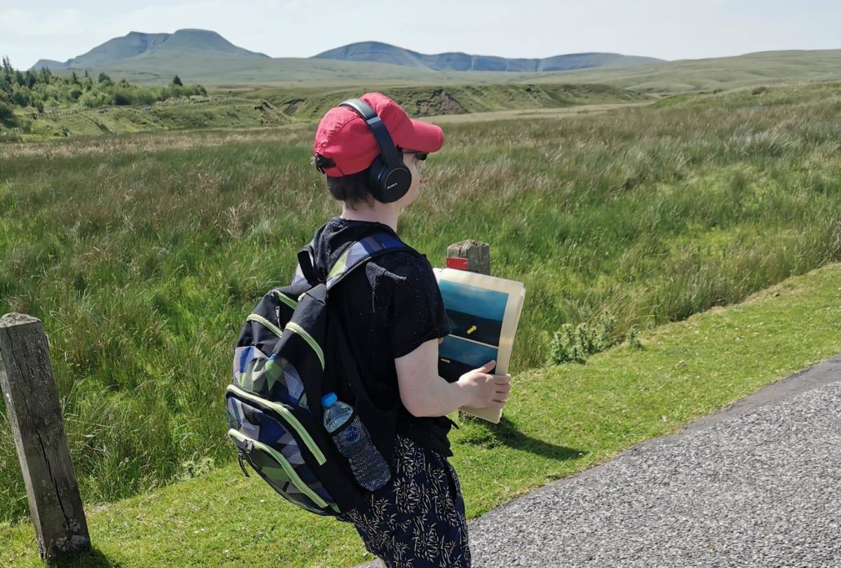 Learner walking wearing headphones.