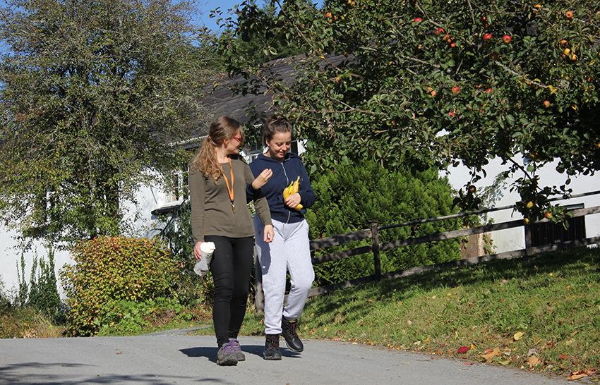 Carer and girl walking around campus.