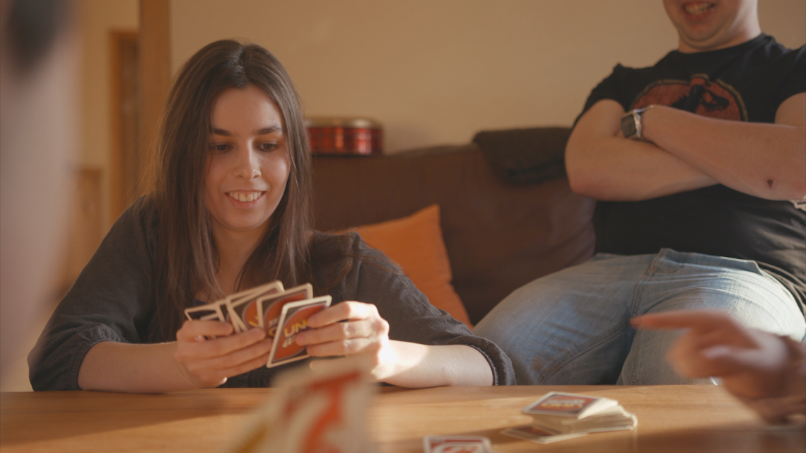Girl playing uno in house.