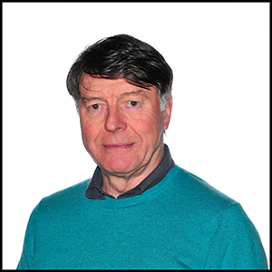 A headshot of a man in a turquoise jumper