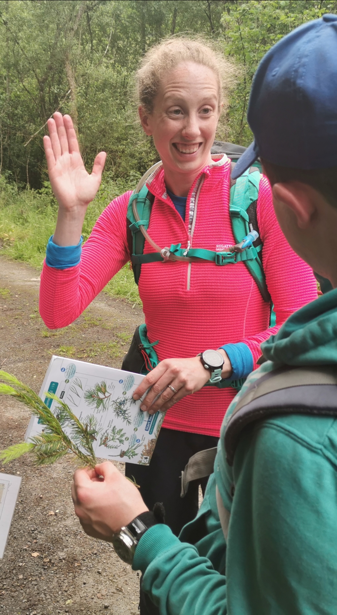 A woman gives a high five. She is wearing a pink top