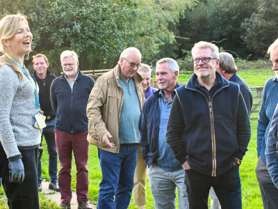 A woman and a group of men outside in a field