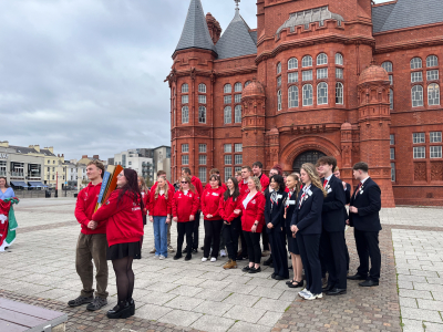 A group of people  outside a redbrick building