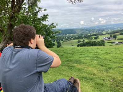 A young man looking through binoculars 