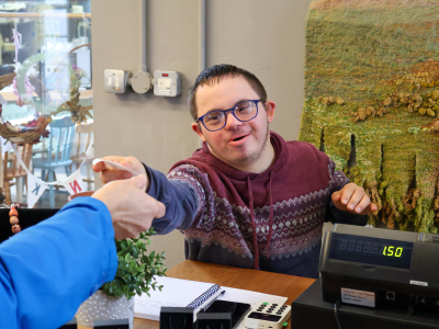 A young man gives change in a shop