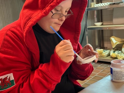 Learner painting pottery.