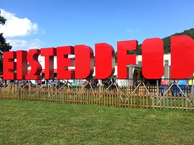 The word EISTEDDFOD in huge red letters in a field in front of a tent.