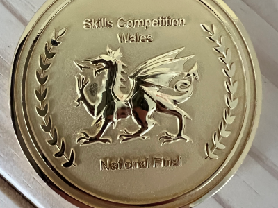 A close up of a gold medal. It says skills competitions Wales national final