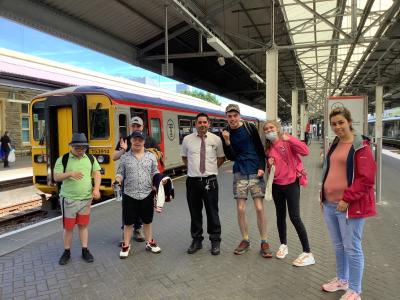 A group 7 people on the train station waiting for the train.